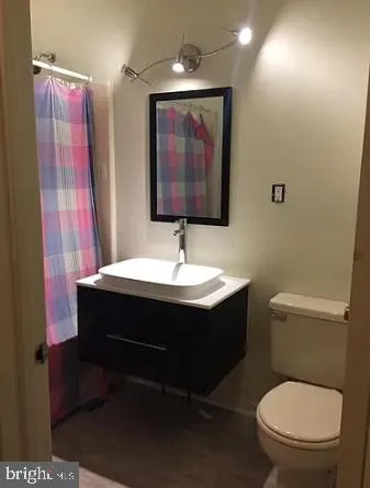 a bathroom with a toilet a sink and mirror