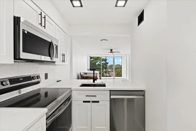 a kitchen with white cabinets and stainless steel appliances