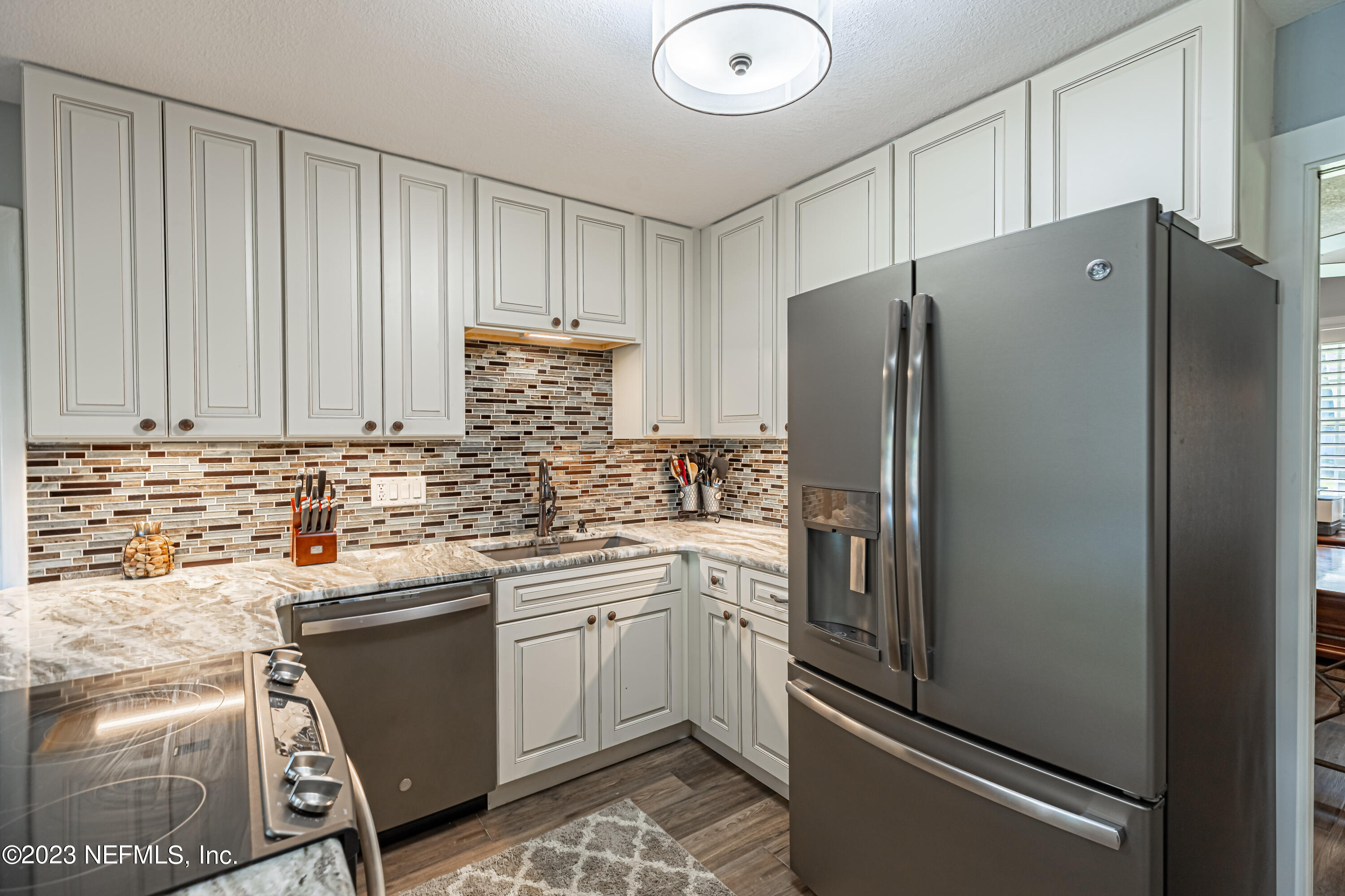 3467 Eunice Road Jacksonville, FL 32250 - Photo 28 of 83 a kitchen with stainless steel appliances a refrigerator sink and cabinets