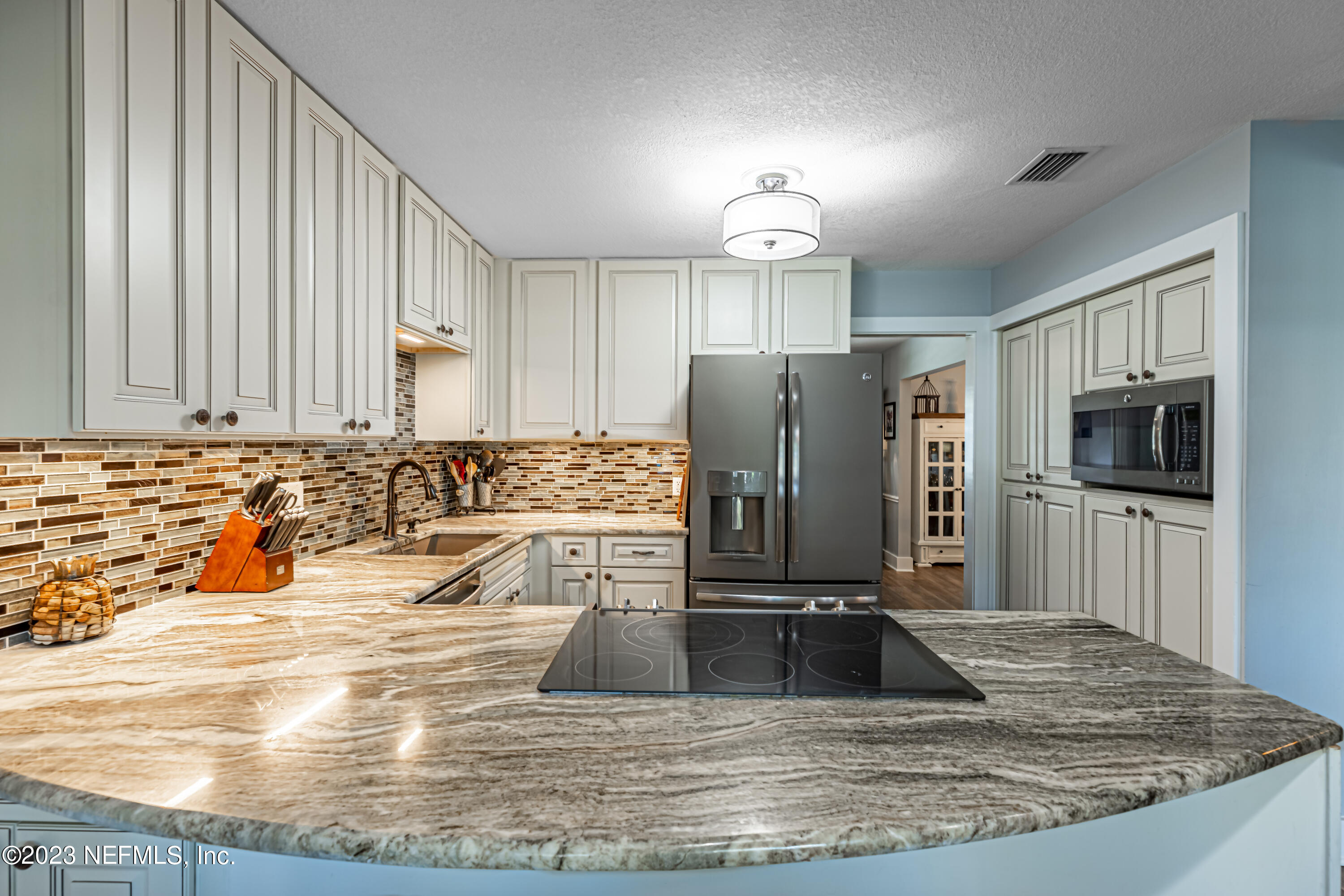 3467 Eunice Road Jacksonville, FL 32250 - Photo 33 of 83 a view of a kitchen with kitchen island a sink stainless steel appliances and cabinets