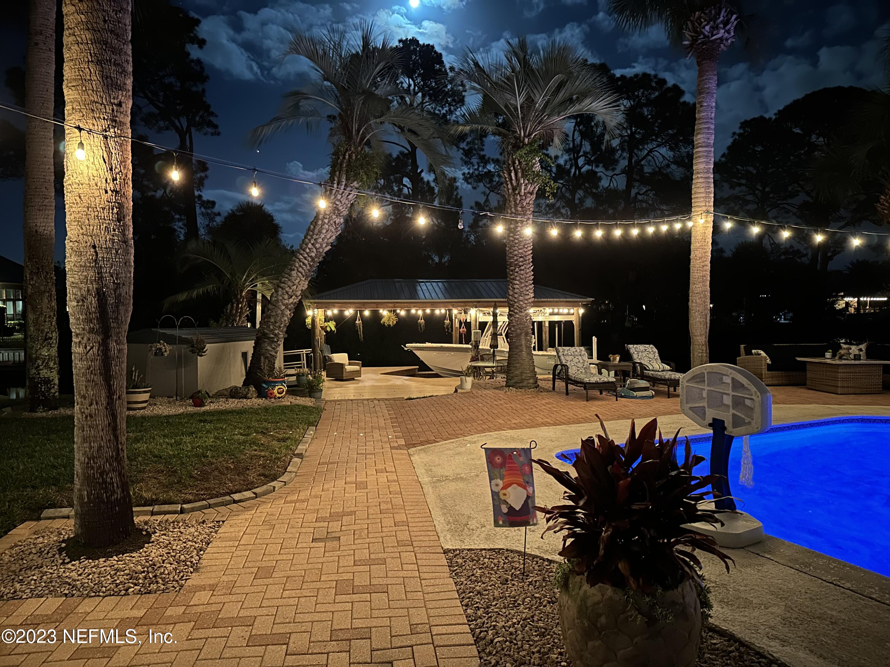 3467 Eunice Road Jacksonville, FL 32250 - Photo 79 of 83 a view of a patio with dining table and chairs with a fire pit and barbeque grill