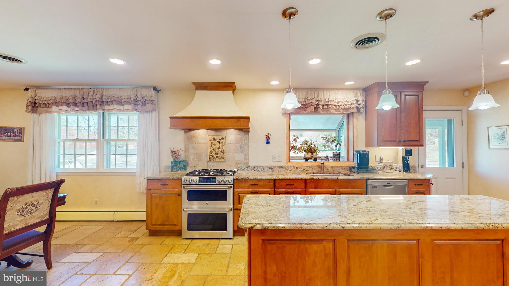 9126 Dunloggin Road Ellicott City, MD 21042 - Photo 7 of 41 a large kitchen with kitchen island a large counter top space a sink a stove and a window