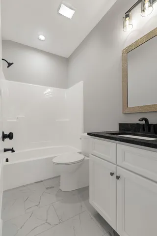 a bathroom with a bathtub a sink a toilet and a mirror