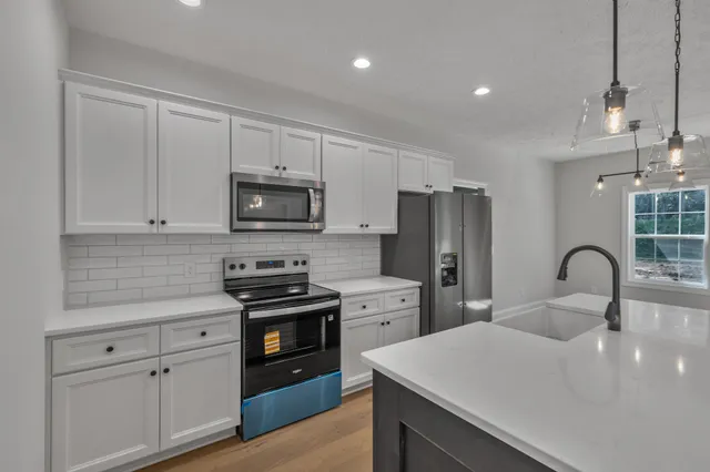 a kitchen with appliances a sink cabinets and a counter top space
