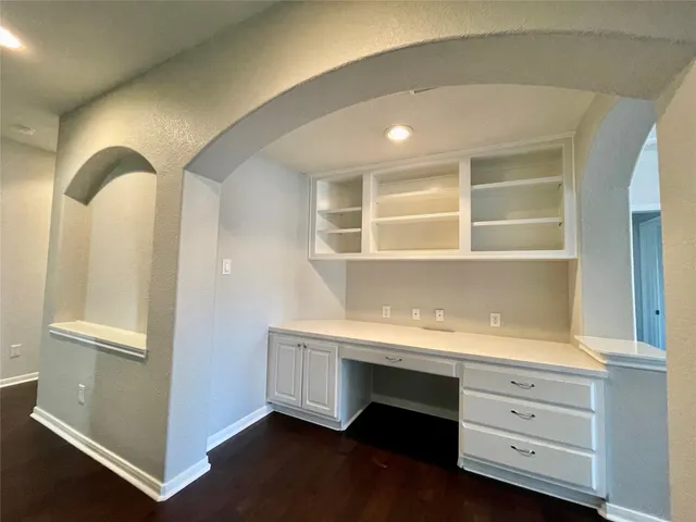 a room with a wooden floor and cabinets