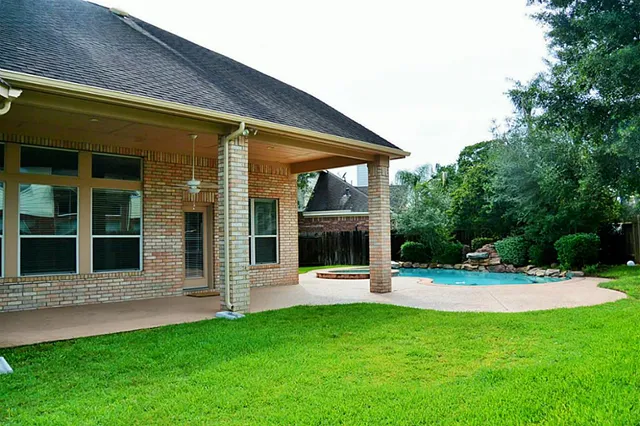 a view of a house with a backyard and a tree