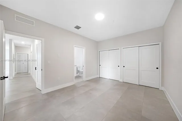 a bathroom with a granite countertop sink toilet and mirror