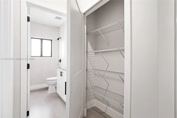 a view of hallway with walk in closet and bathroom