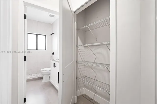 a view of hallway with walk in closet and bathroom