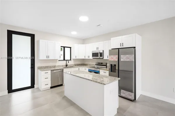 a kitchen with refrigerator and cabinets