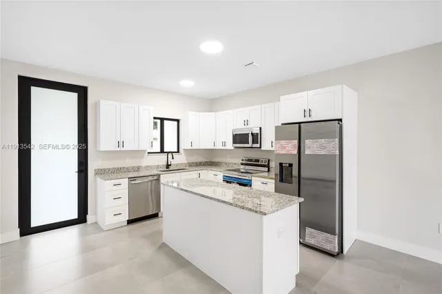 a kitchen with refrigerator and cabinets