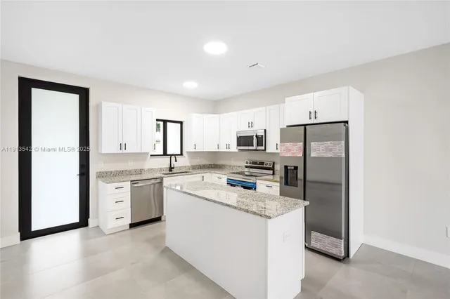 a kitchen with refrigerator and cabinets