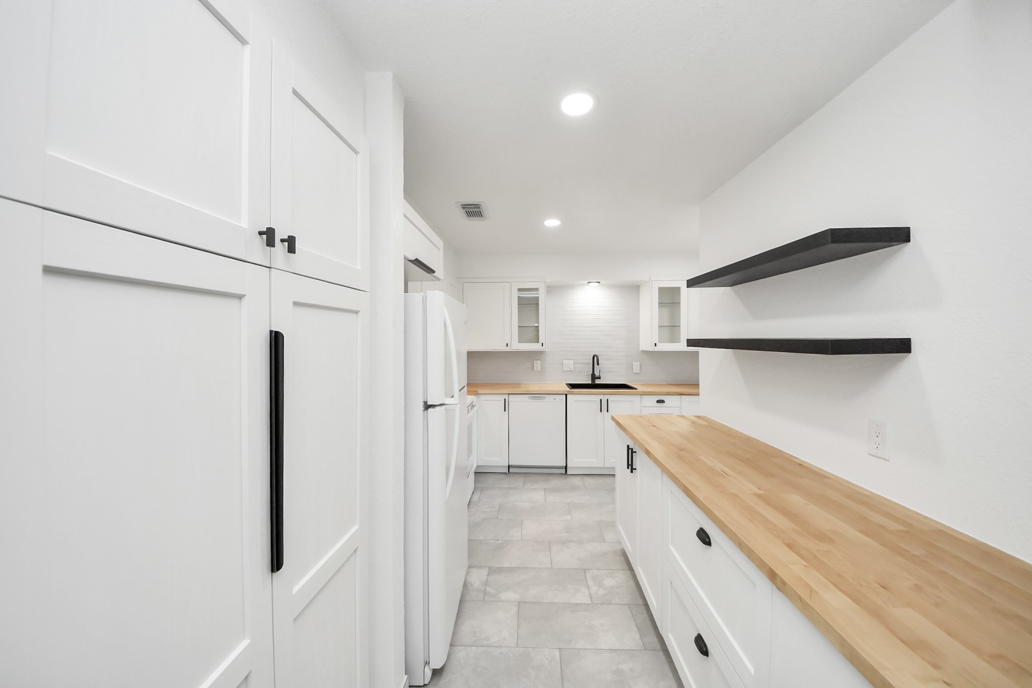 6601 Sands Point Drive, Unit 47 Houston, TX 77074 - Photo 13 of 46 a large white kitchen with cabinets and a refrigerator