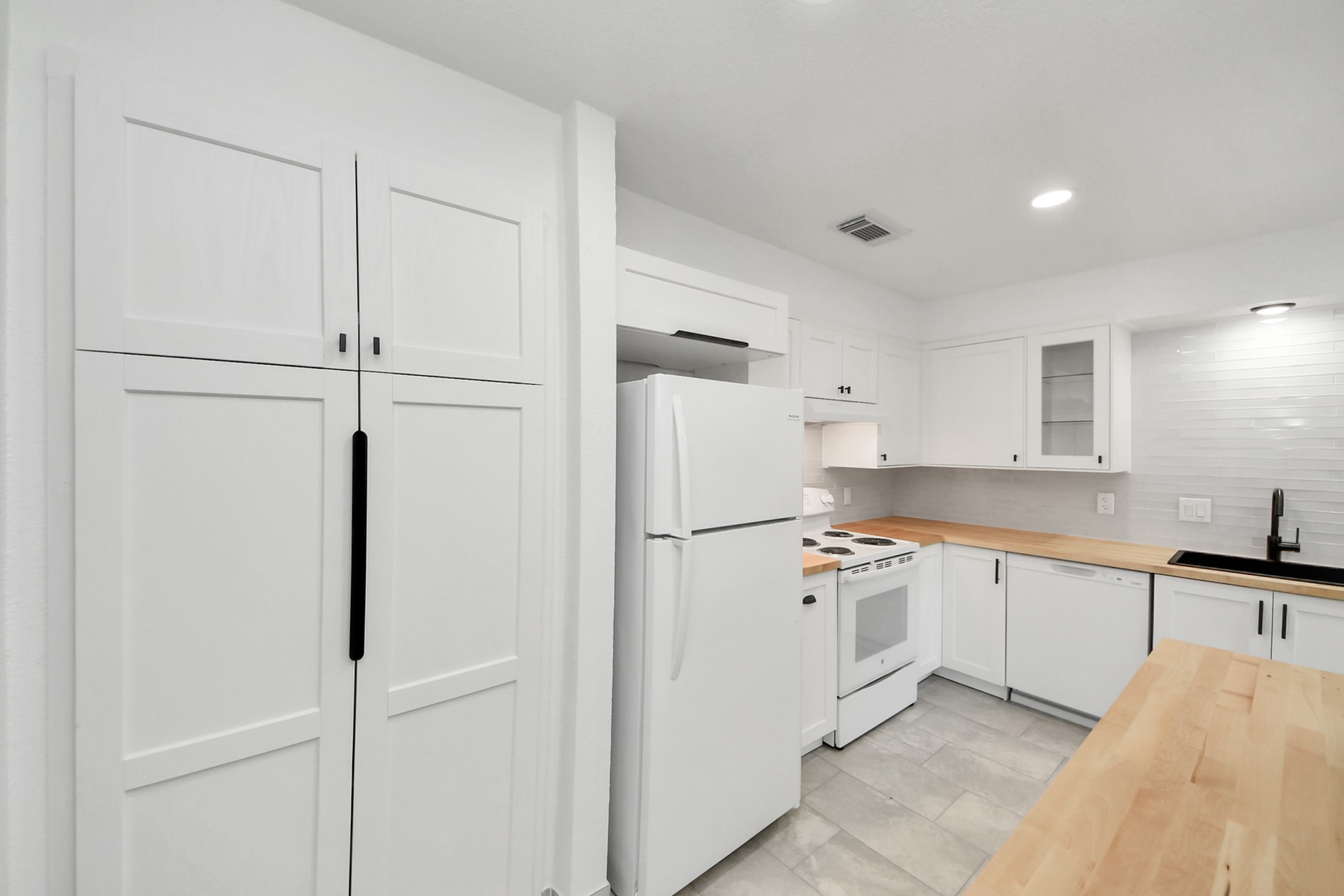 6601 Sands Point Drive, Unit 47 Houston, TX 77074 - Photo 15 of 46 a kitchen with white cabinets and white appliances