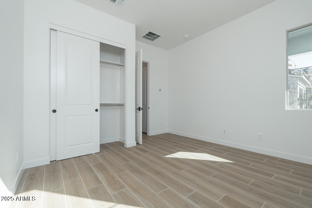 1244 East Prescott Street Gilbert, AZ 85298 - Photo 12 of 17 a view of an empty room with wooden floor and a window