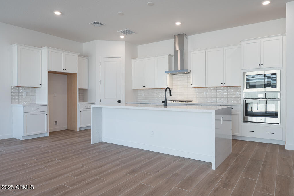 1244 East Prescott Street Gilbert, AZ 85298 - Photo 2 of 17 a kitchen with stainless steel appliances granite countertop a refrigerator sink and white cabinets with wooden floor
