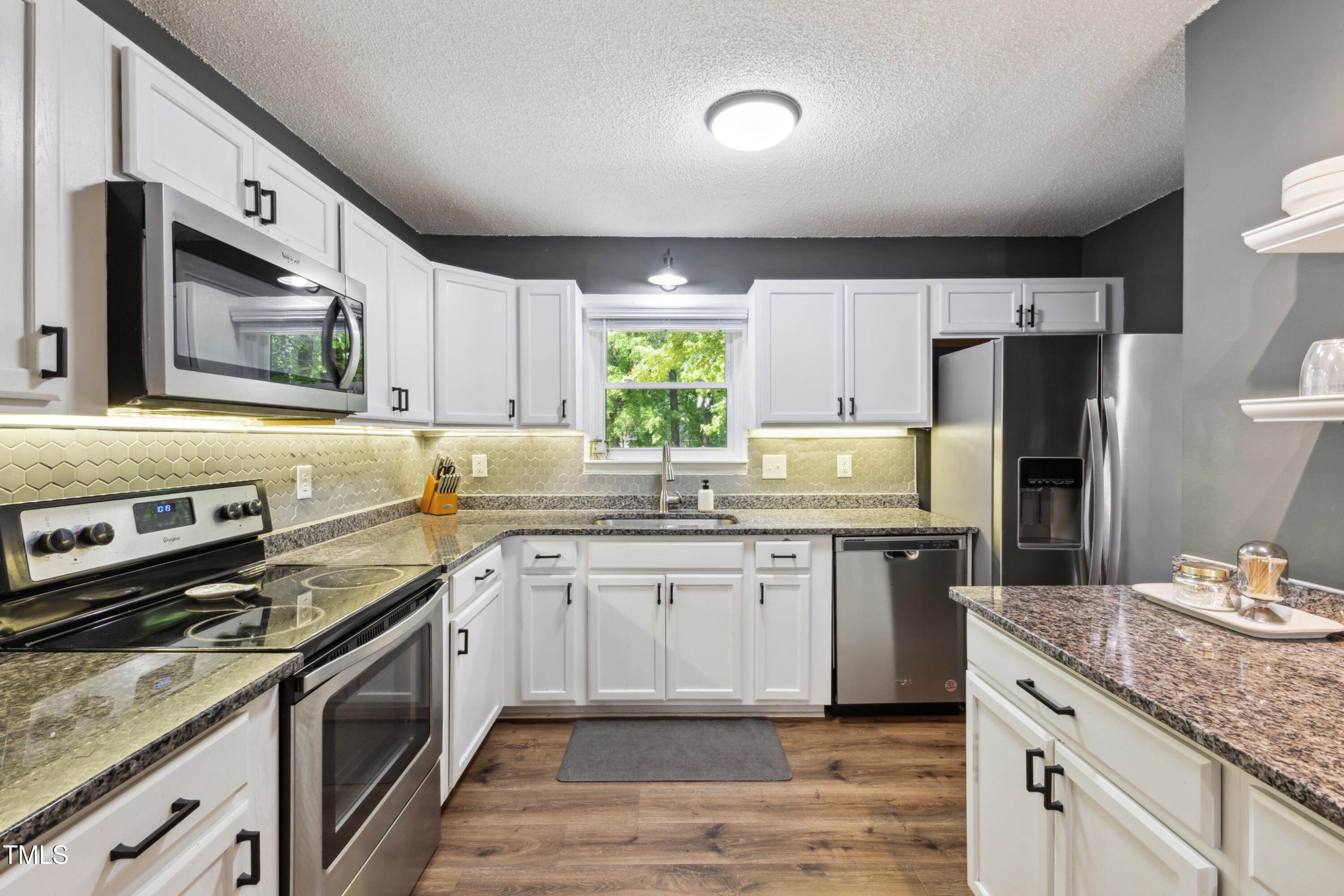 5775 Forest Lawn Court Raleigh, NC 27612 - Photo 16 of 45 a kitchen with stainless steel appliances granite countertop a sink stove and refrigerator