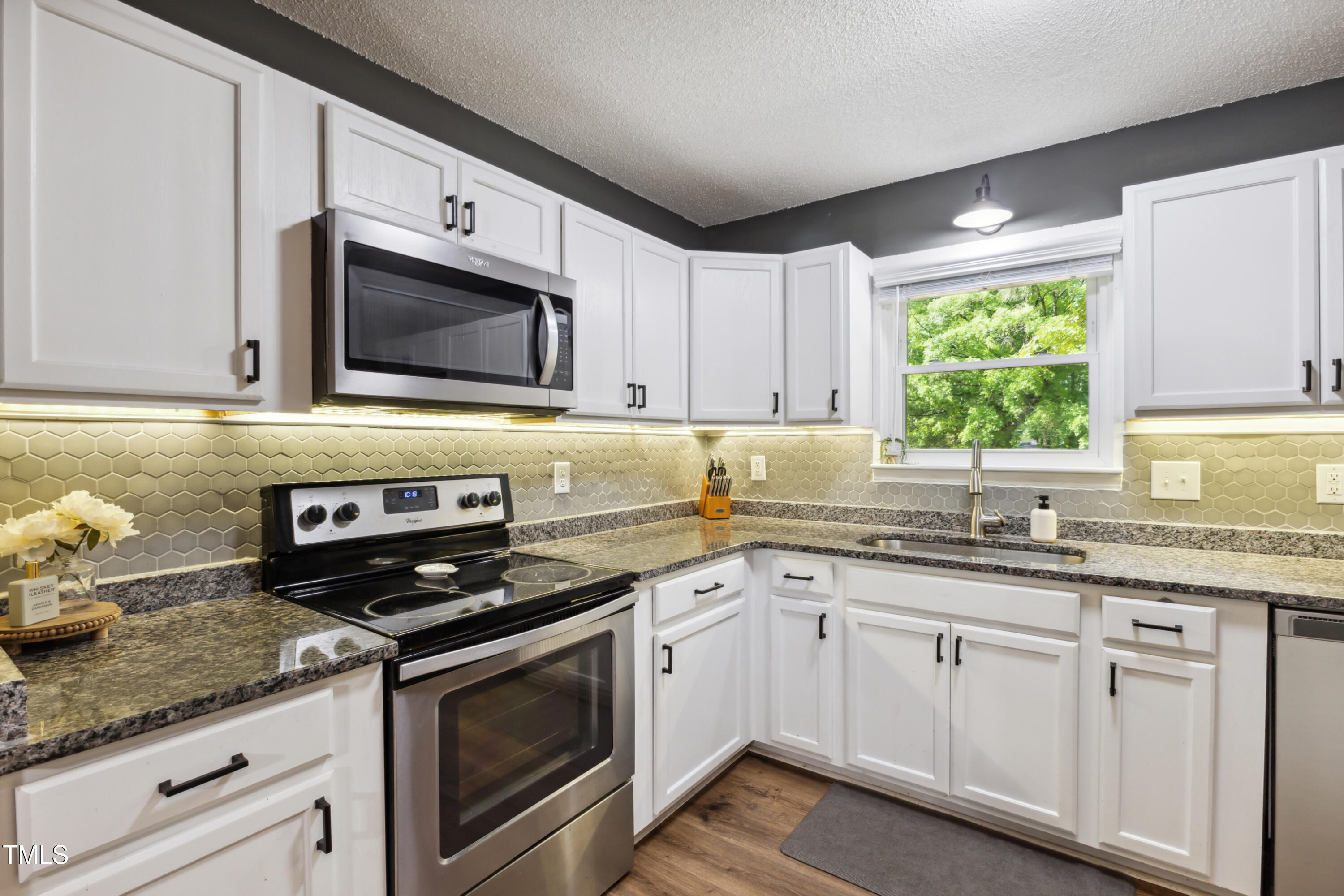 5775 Forest Lawn Court Raleigh, NC 27612 - Photo 17 of 45 a kitchen with granite countertop white cabinets white appliances and a sink