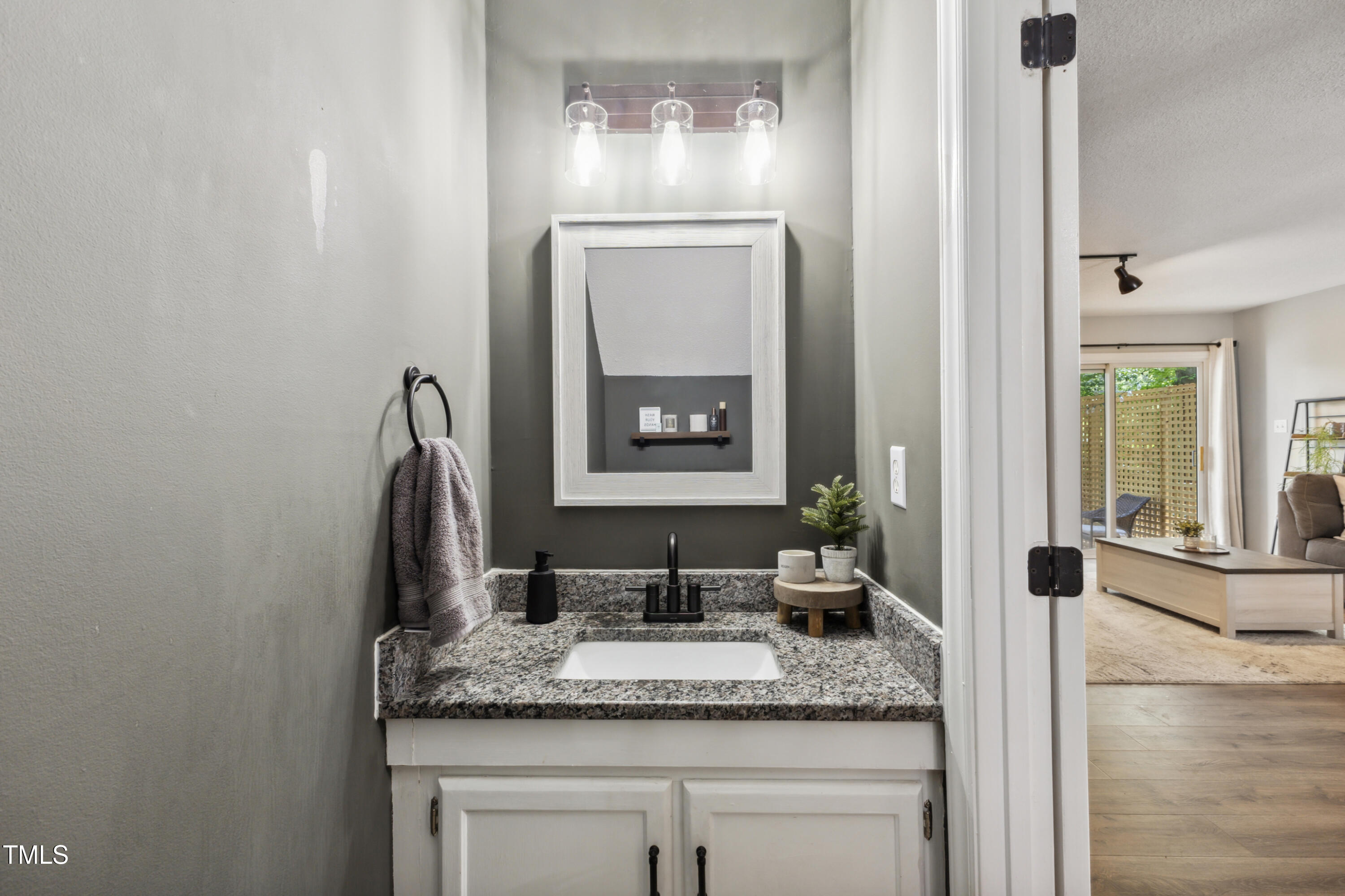 5775 Forest Lawn Court Raleigh, NC 27612 - Photo 26 of 45 a bathroom with a granite countertop sink and a mirror