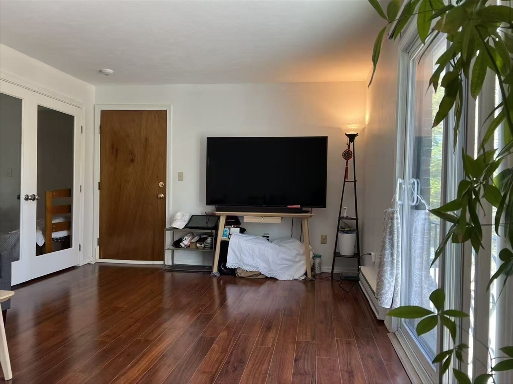 382 Great Road, Unit B303 Acton, MA 01720 - Photo 1 of 8 a living room with furniture and a flat screen tv