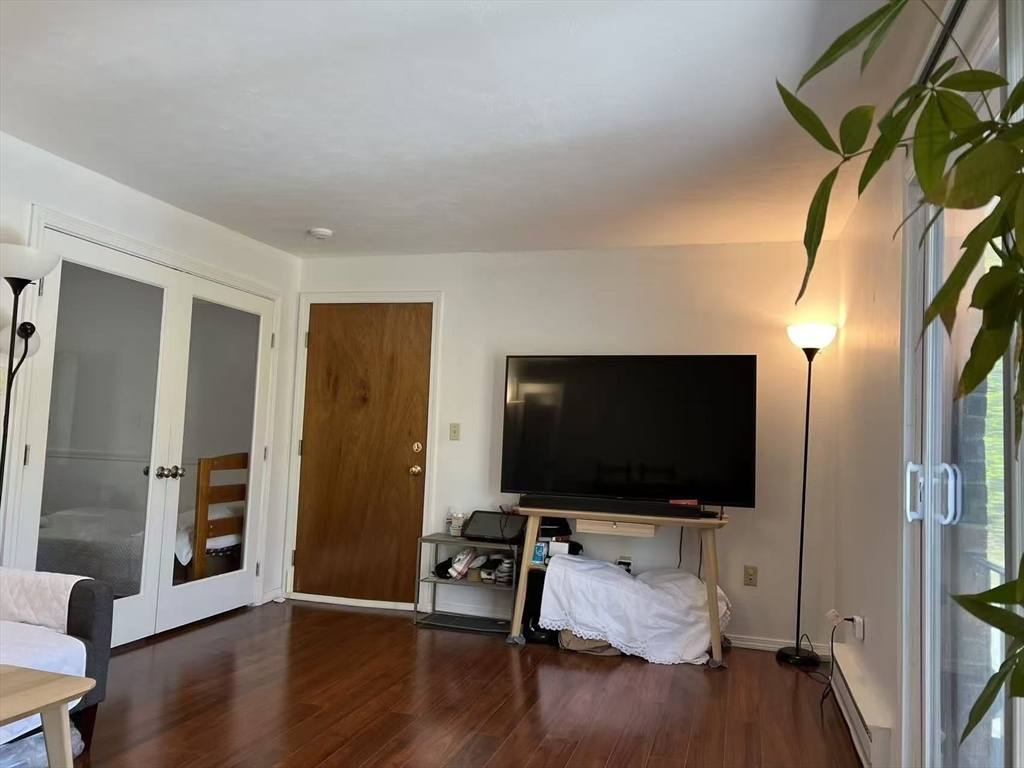 382 Great Road, Unit B303 Acton, MA 01720 - Photo 7 of 8 a living room with furniture and a flat screen tv