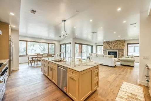 a kitchen with stainless steel appliances kitchen island granite countertop a stove and white cabinets