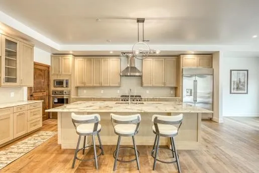 a kitchen with stainless steel appliances granite countertop a stove a sink and a refrigerator