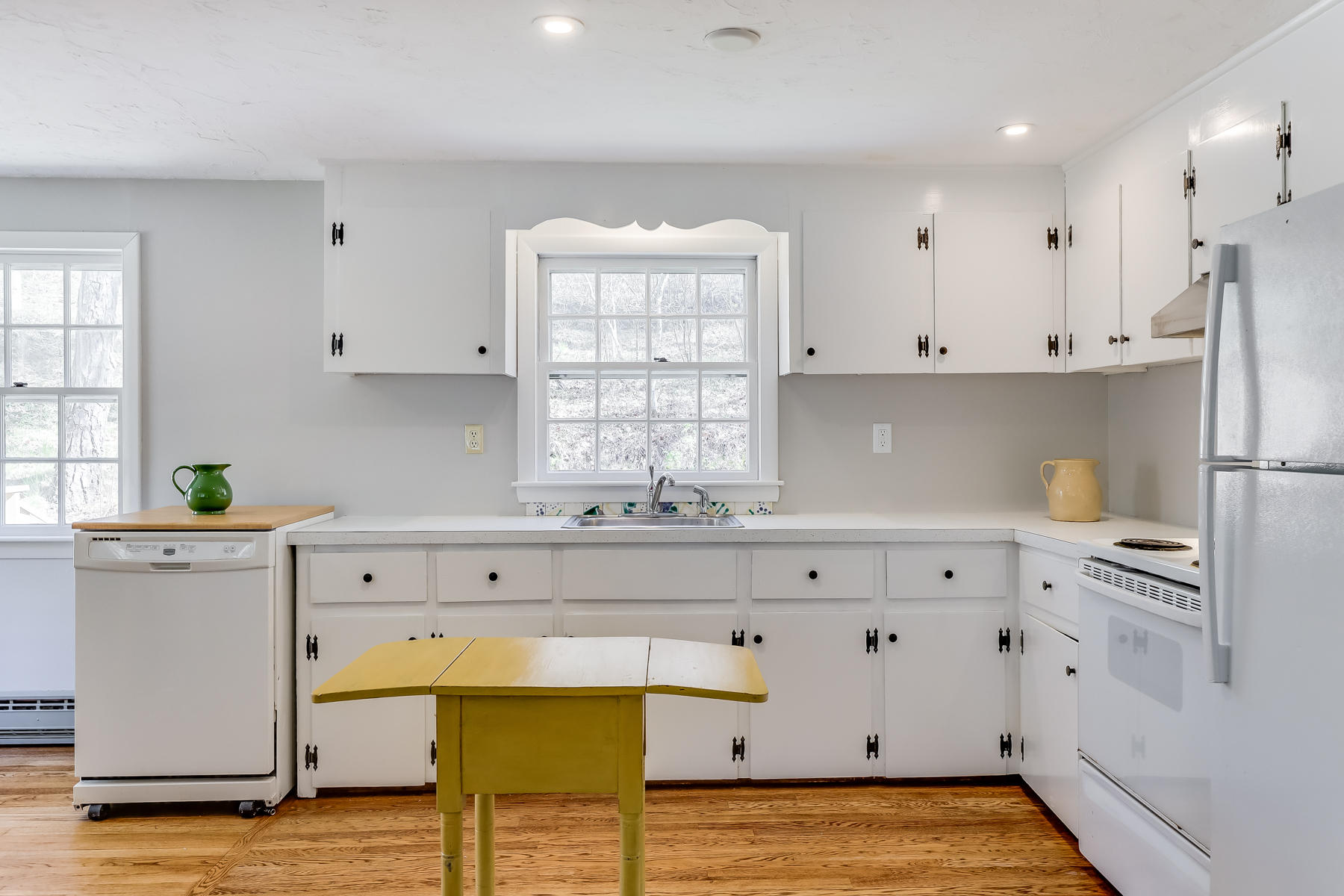 35 Higgins Hollow Road Truro, MA 02666 - Photo 6 of 20 a kitchen with stainless steel appliances white cabinets and wooden floor