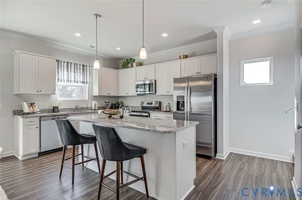 a kitchen with stainless steel appliances granite countertop a white cabinets and wooden floor