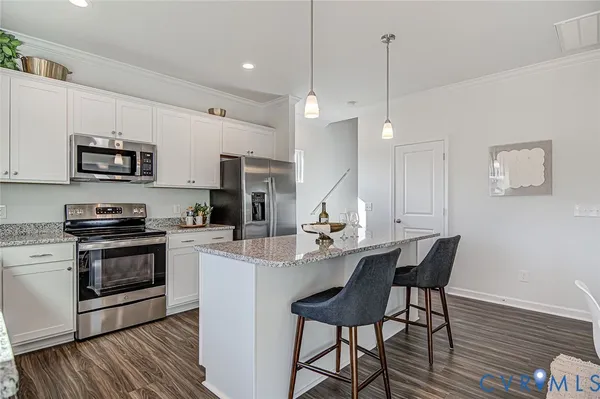 a kitchen with kitchen island a stove a table and chairs in it