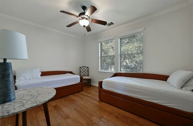 a bedroom with a large bed a chandelier and a window