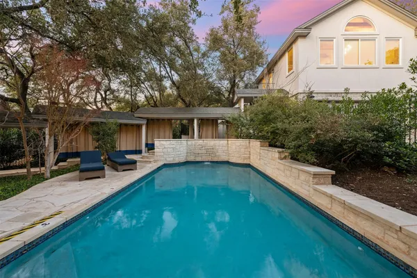 a view of a house with pool and chairs