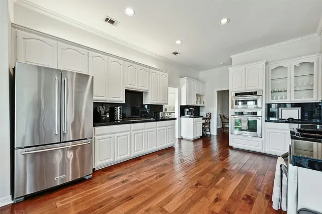 a kitchen with stainless steel appliances a refrigerator and a stove top oven