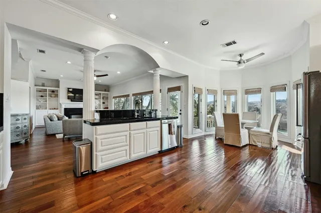 a large living room with stainless steel appliances furniture and a wooden floor