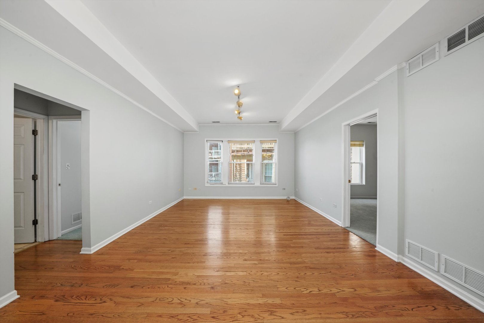 4536 North Sheridan Road, Unit 204 Chicago, IL 60640 - Photo 3 of 24 a view of an empty room with window and wooden floor