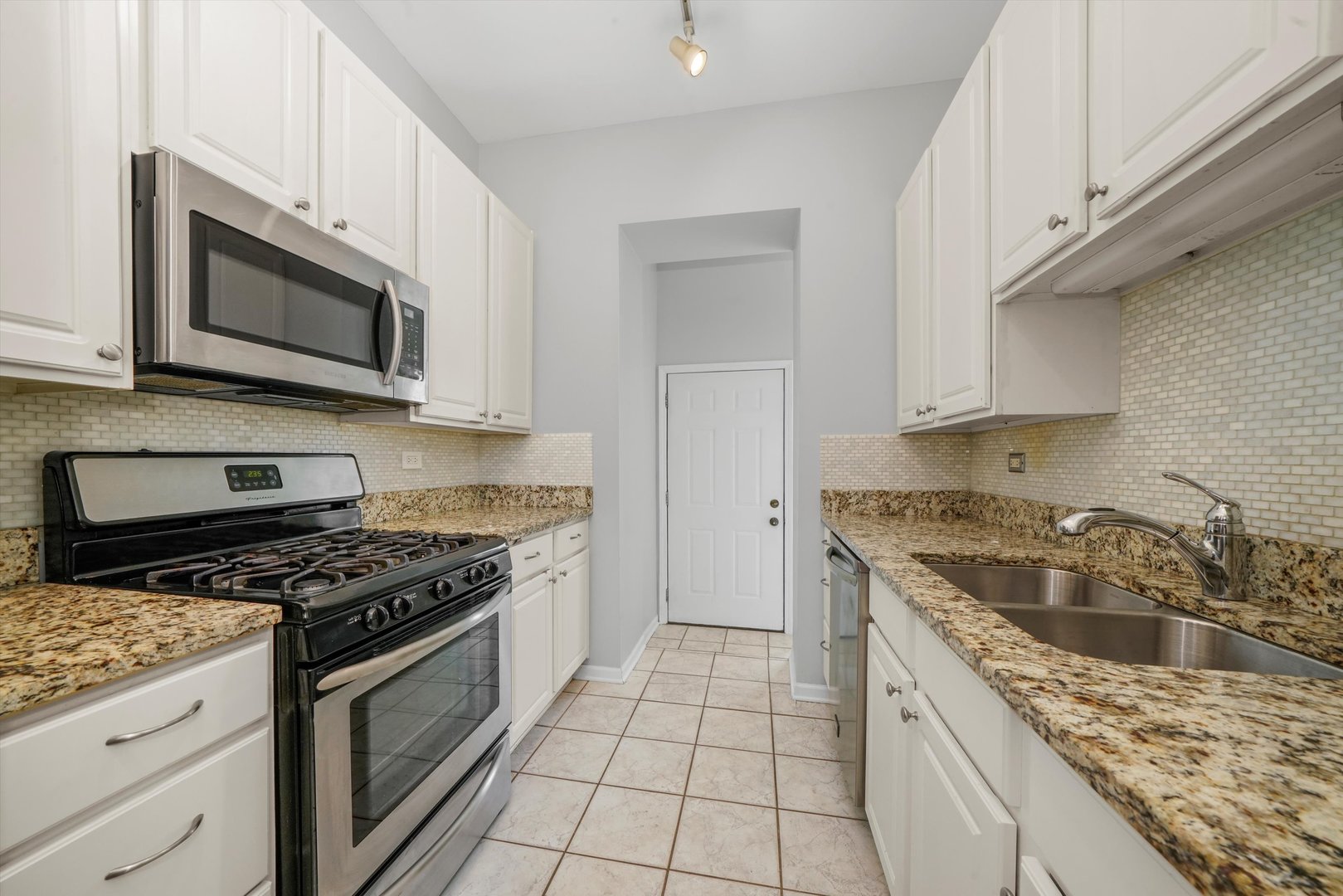 4536 North Sheridan Road, Unit 204 Chicago, IL 60640 - Photo 8 of 24 a kitchen with stainless steel appliances granite countertop a sink stove and microwave