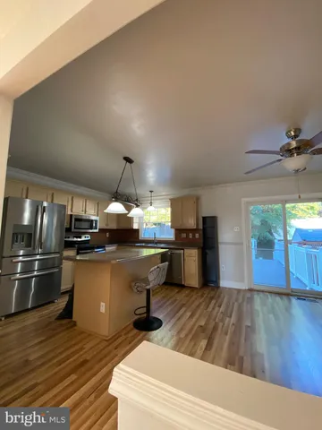 a open kitchen with kitchen island a stove and a wooden floors