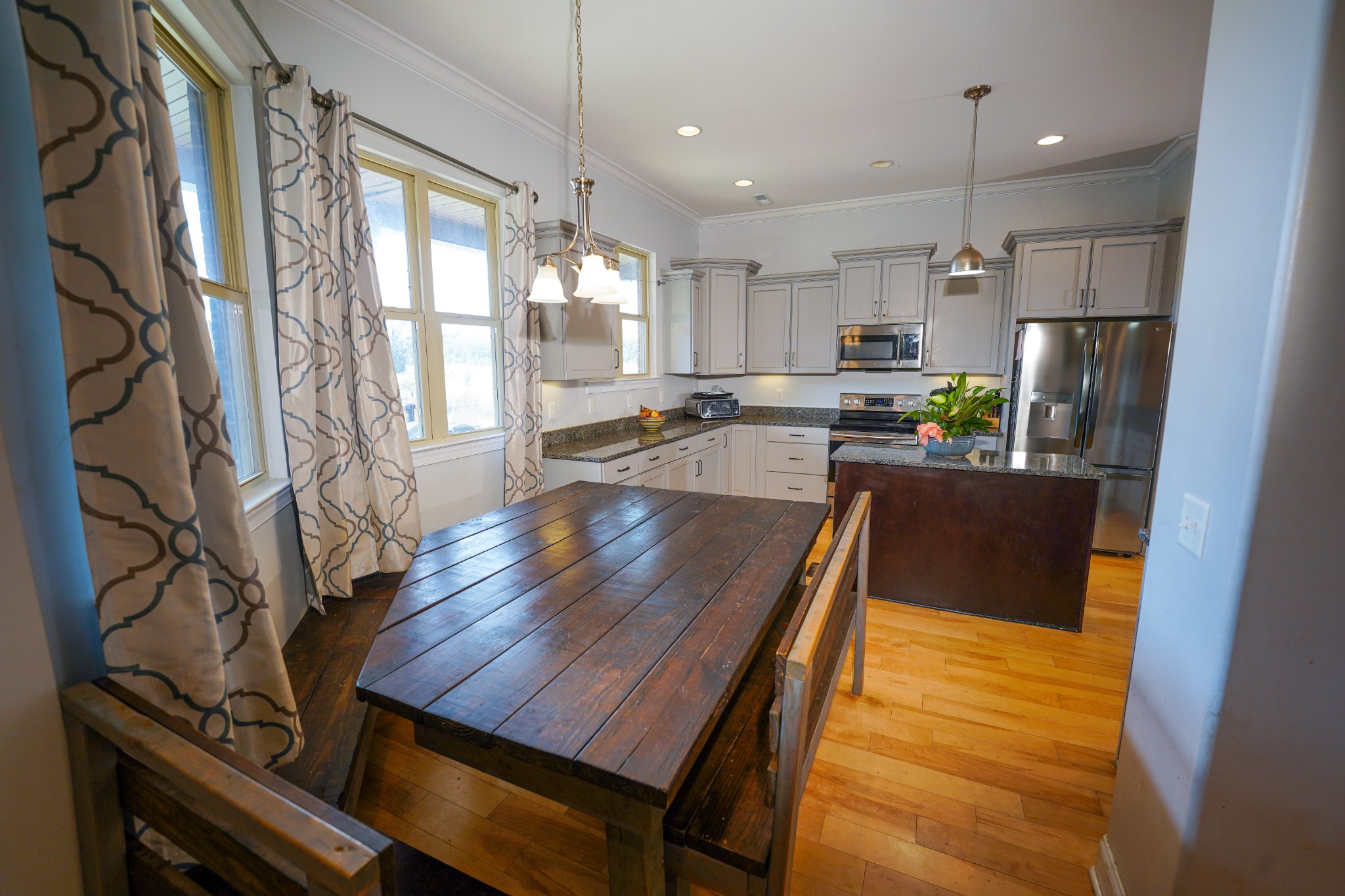 2172 Fellowship Road Mount Juliet, TN 37122 - Photo 27 of 53 a kitchen with stainless steel appliances granite countertop a stove a refrigerator a oven a sink a dining table and chairs with wooden floor