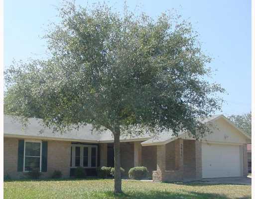 a view of a yard in front of a house with large tree