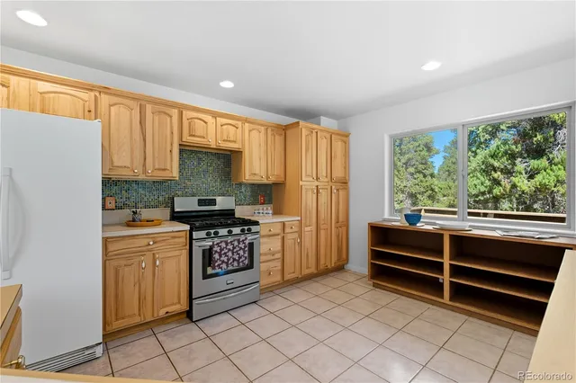 a large kitchen with granite countertop a sink window and cabinets