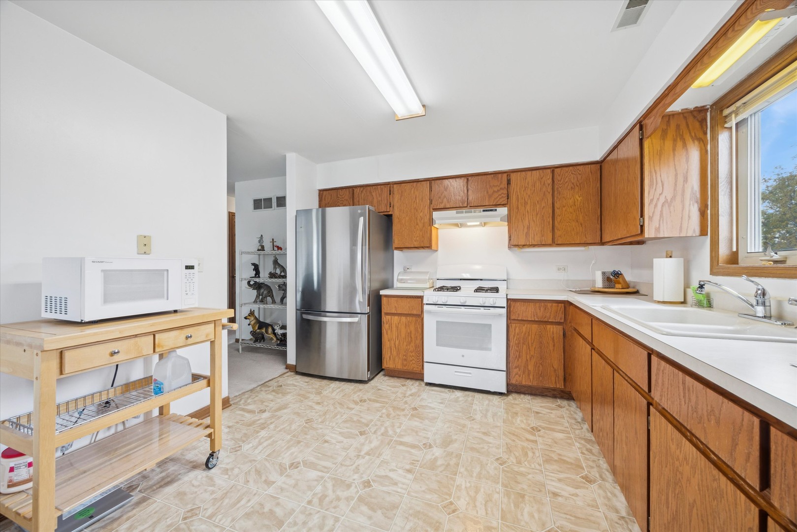 2689 Jodee Drive, Unit B Joliet, IL 60436 - Photo 9 of 16 a kitchen with stainless steel appliances a refrigerator sink and cabinets