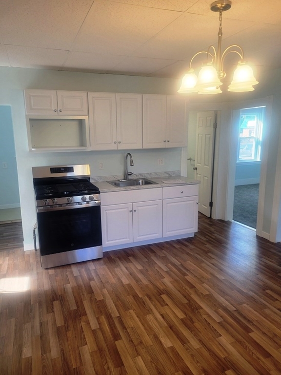 a kitchen with granite countertop a stove a sink and a refrigerator