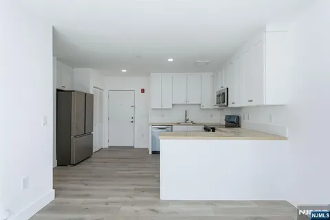 a kitchen with a refrigerator sink and cabinets