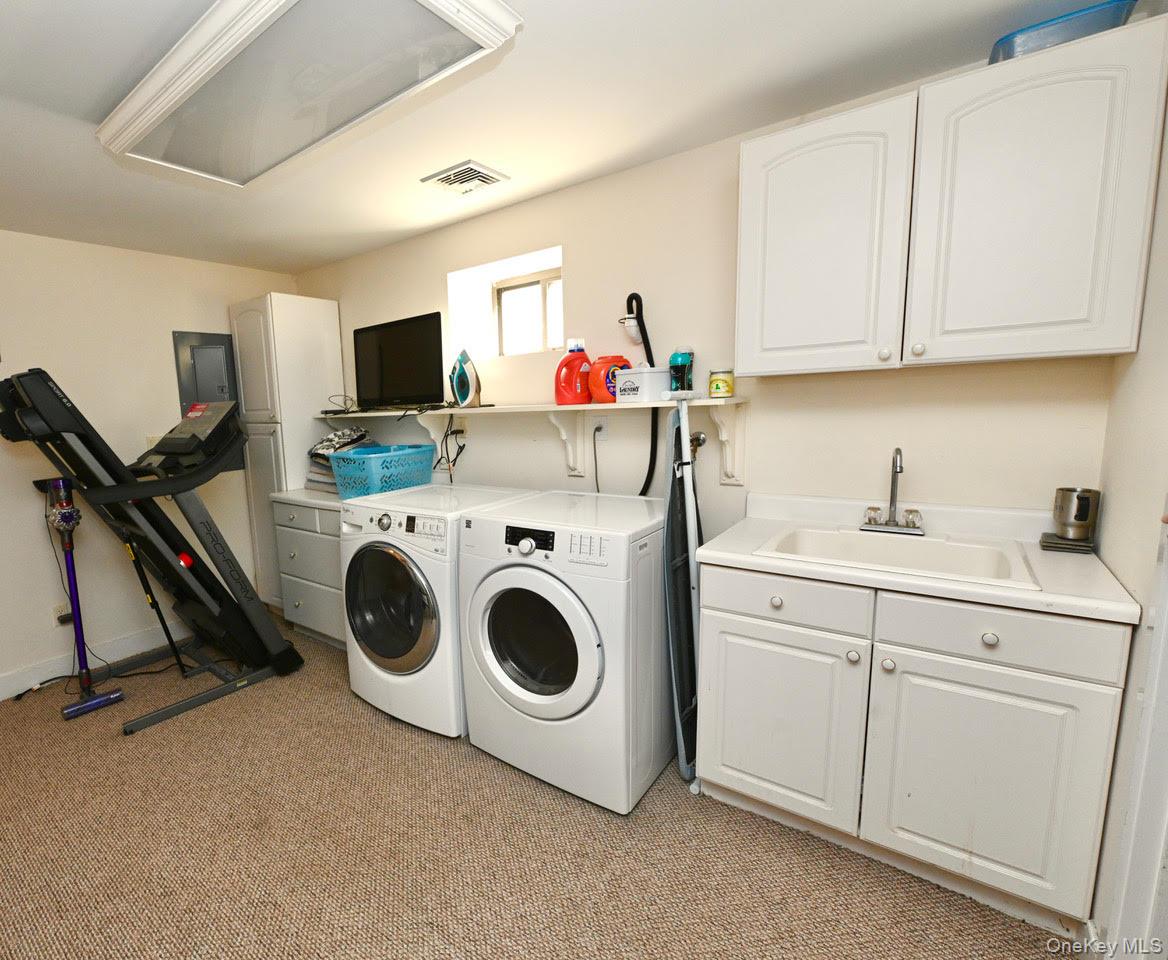 216 5th Street St. James, NY 11780 - Photo 20 of 21 Laundry room featuring cabinet space, independent washer and dryer, light carpet, and electric panel
