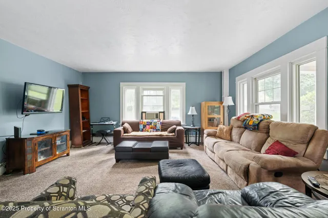 a living room with furniture and large windows