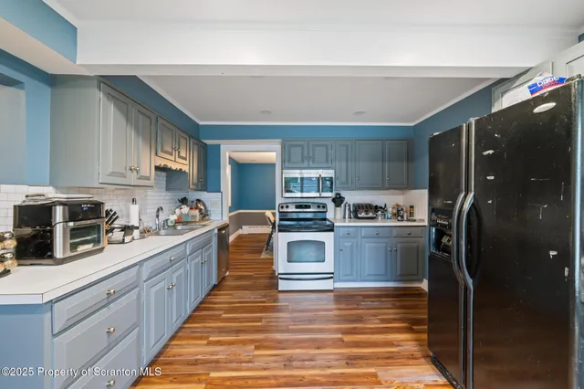 a kitchen with granite countertop a refrigerator stove and sink