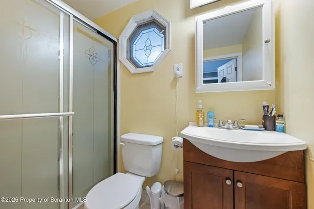 a bathroom with a sink toilet a mirror and shower