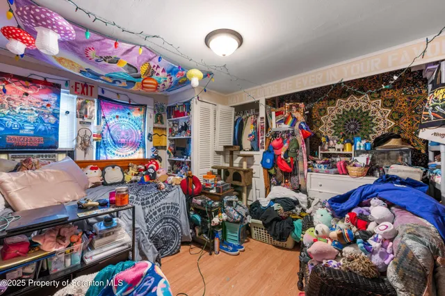 a bedroom with a bed and a flat tv screen on dresser