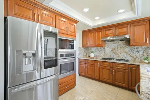 a kitchen with stainless steel appliances granite countertop a refrigerator and a stove top oven