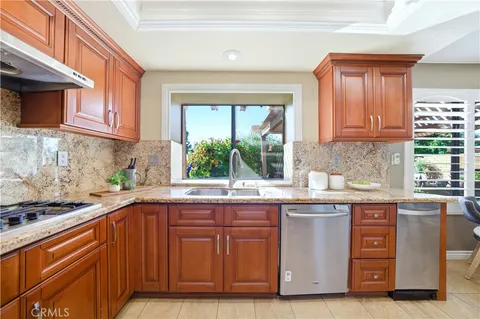 a kitchen with stainless steel appliances granite countertop a sink and a stove